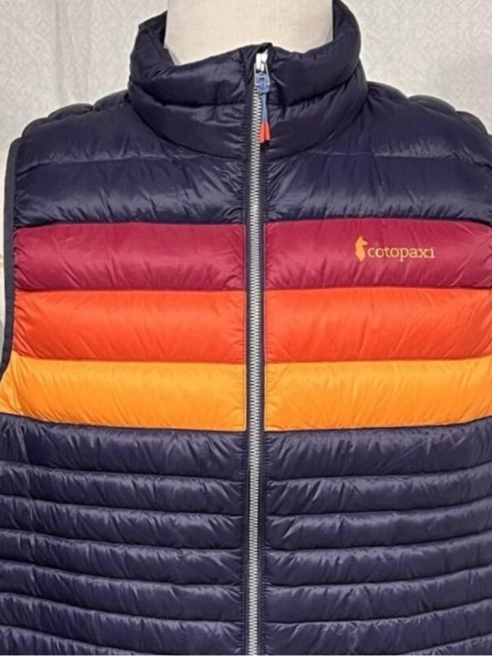 cotopaxi Navy Puffer Vest with Red, Orange & Yellow Stripes